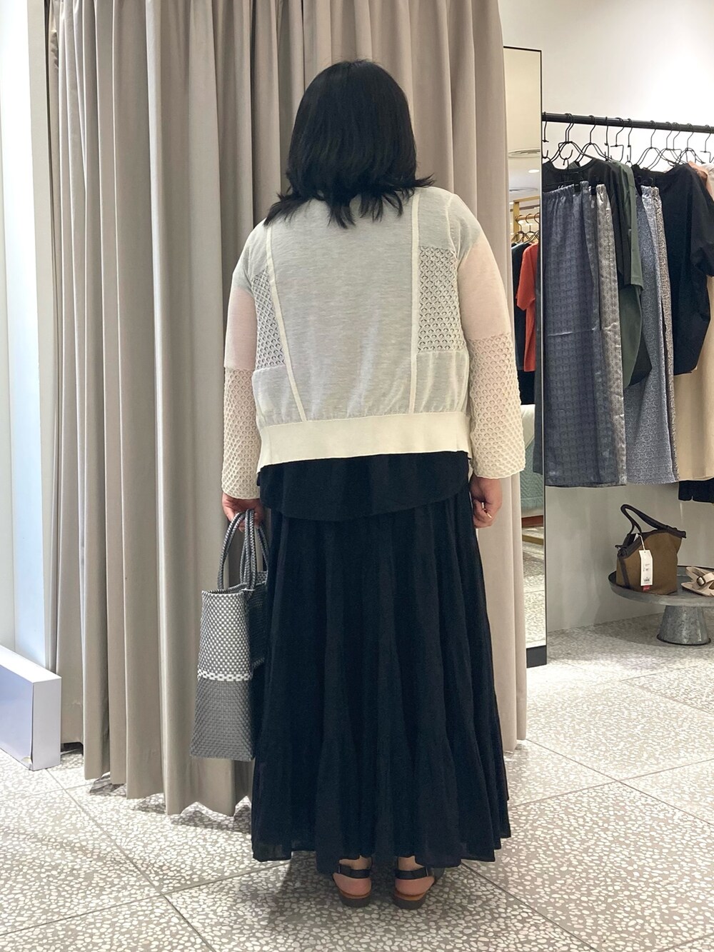 ブラック系のシャツ/ブラウス、シルバー系のかごバッグ、ブラック系のサンダルを着用したレディースの夏コーディネートの3枚目の写真