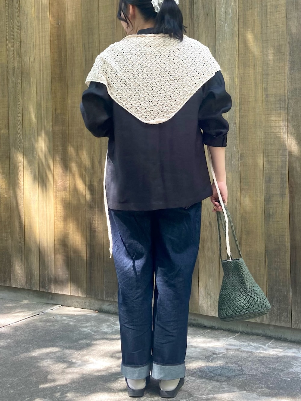 グリーン系のかごバッグ、ブルー系のデニムパンツ、ブルー系のTシャツ/カットソーを着用したレディースの春コーディネートの3枚目の写真