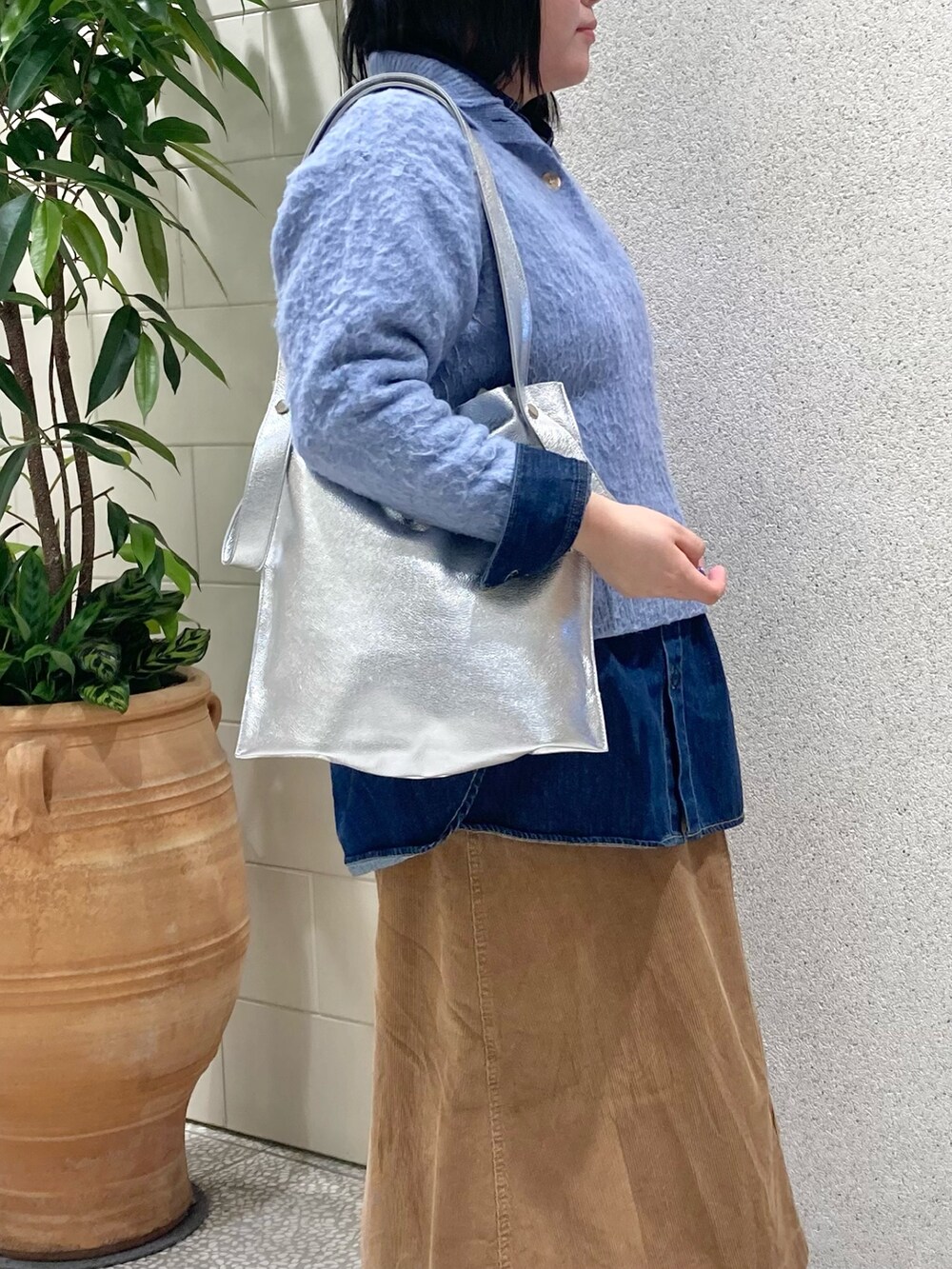 ブルー系のニット/セーター、シルバー系のトートバッグを着用したレディースの冬コーディネートの2枚目の写真