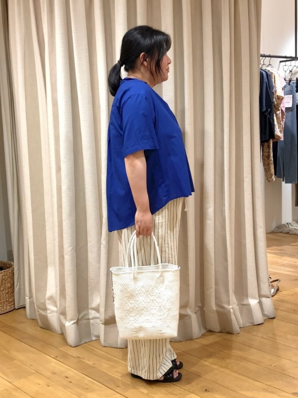 ブルー系のシャツ/ブラウス、ホワイト系のかごバッグ、その他のネックレスを着用したレディースの春コーディネートの3枚目の写真