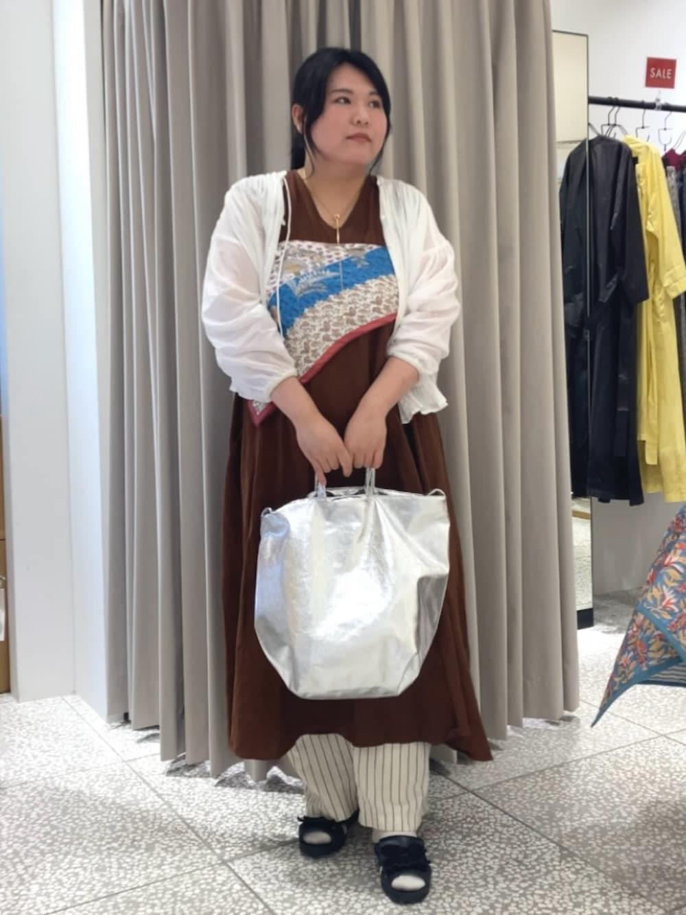 ホワイト系のシャツ/ブラウス、ブラウン系のワンピース、シルバー系のトートバッグを着用したレディースの夏コーディネートの2枚目の写真