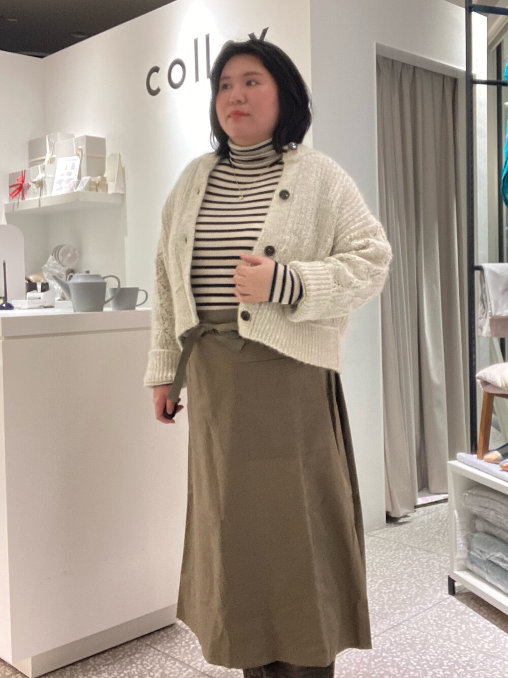 ブラウン系のその他パンツ、ブラック系のその他シューズ、グリーン系のエプロンを着用したレディースの冬コーディネートの9枚目の写真