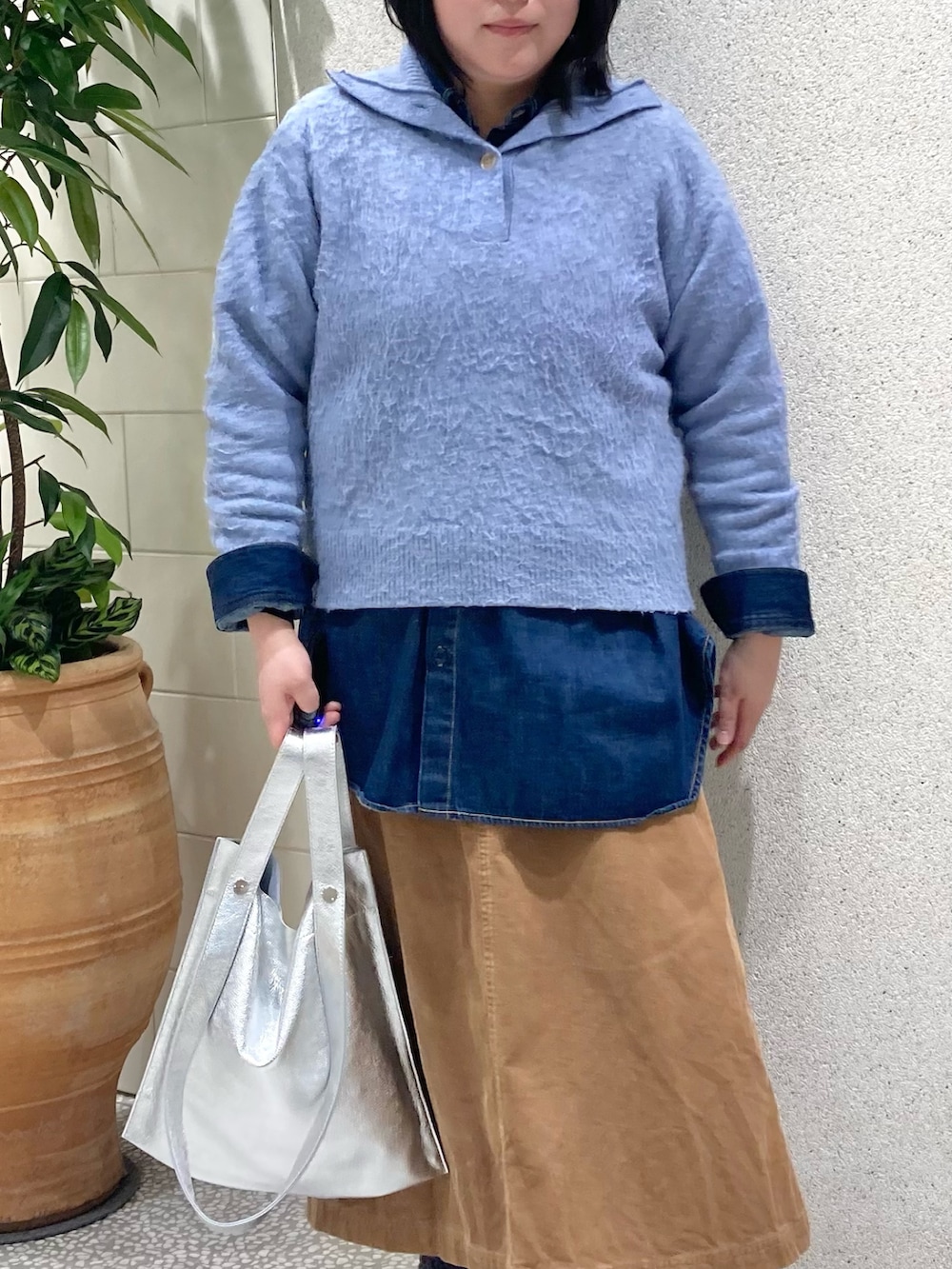 ブルー系のニット/セーター、シルバー系のトートバッグを着用したレディースの冬コーディネートの3枚目の写真