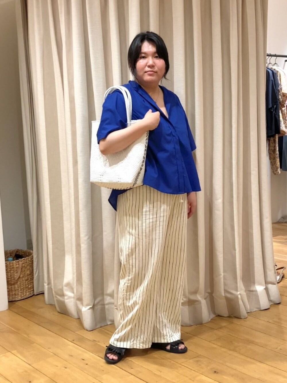 ブルー系のシャツ/ブラウス、ホワイト系のかごバッグ、その他のネックレスを着用したレディースの春コーディネートの7枚目の写真