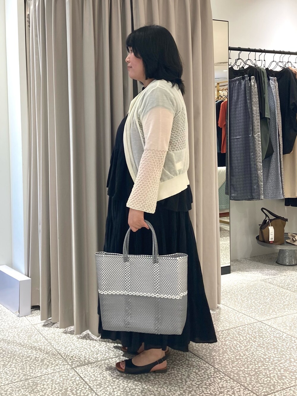 ブラック系のシャツ/ブラウス、シルバー系のかごバッグ、ブラック系のサンダルを着用したレディースの夏コーディネートの2枚目の写真