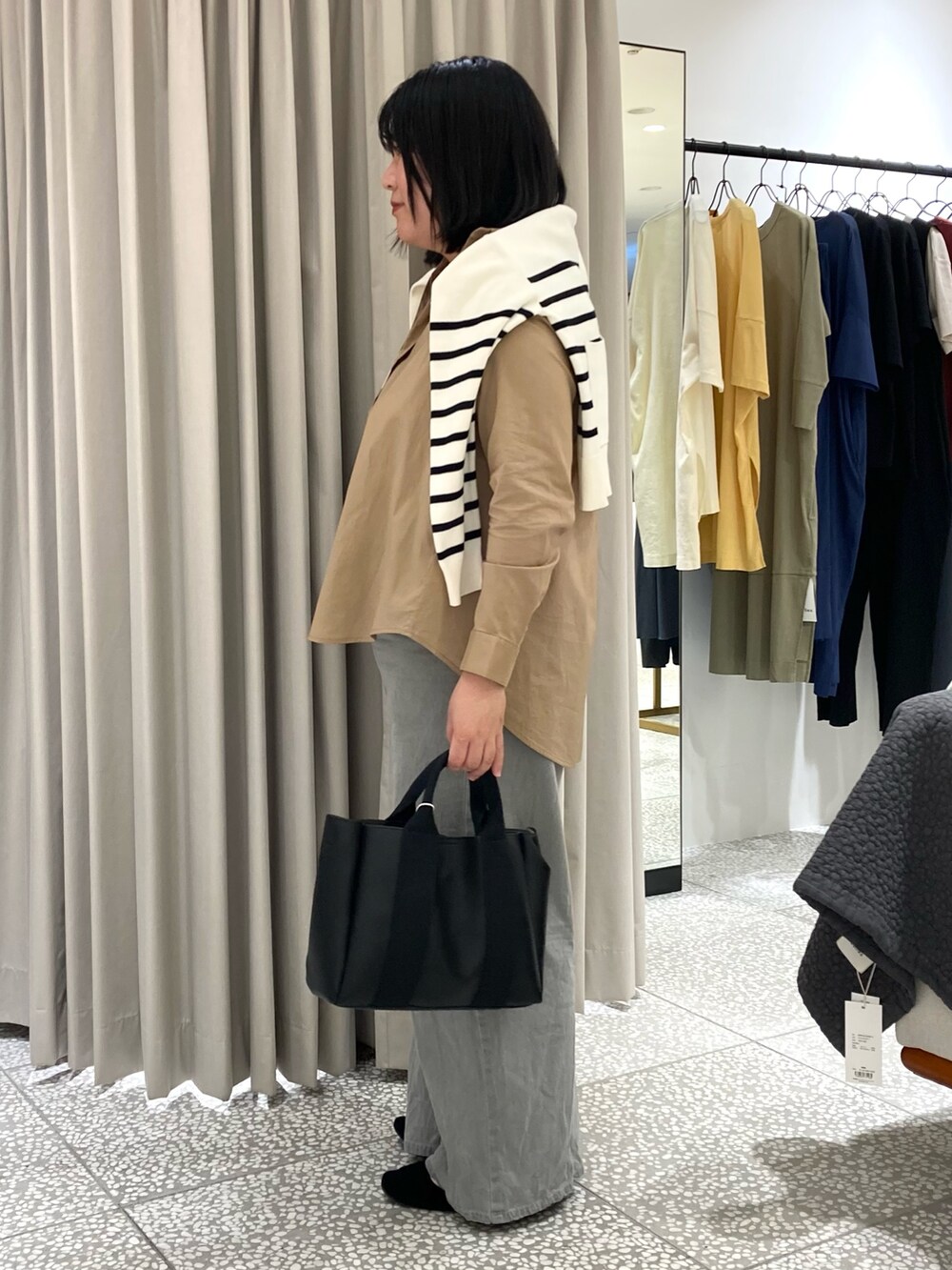 ホワイト系のカーディガン/ボレロ、ベージュ系のシャツ/ブラウス、ブラック系のトートバッグを着用したレディースの秋コーディネートの3枚目の写真