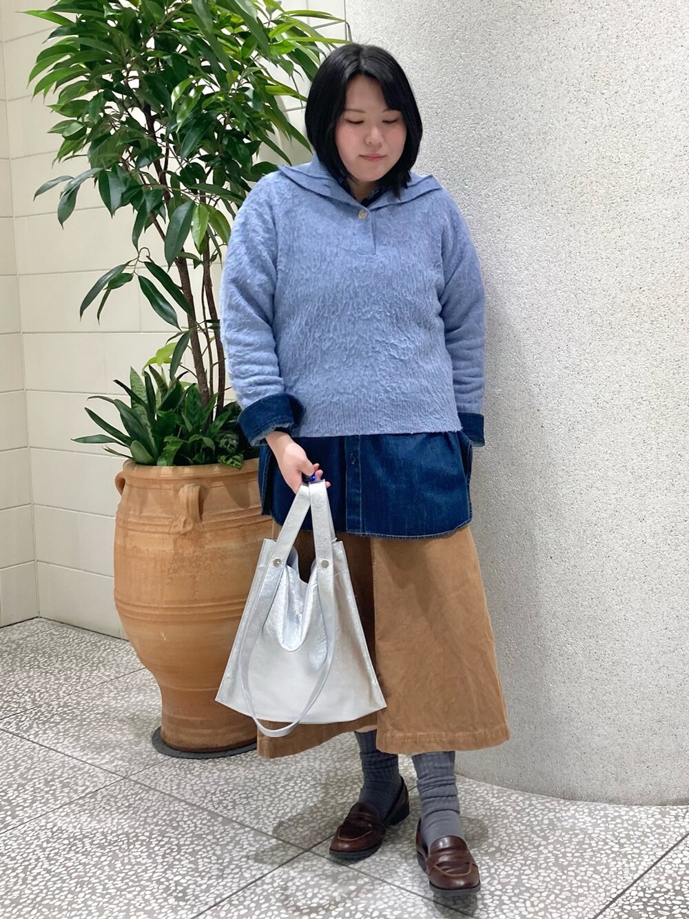 ブルー系のニット/セーター、シルバー系のトートバッグを着用したレディースの冬コーディネートの5枚目の写真