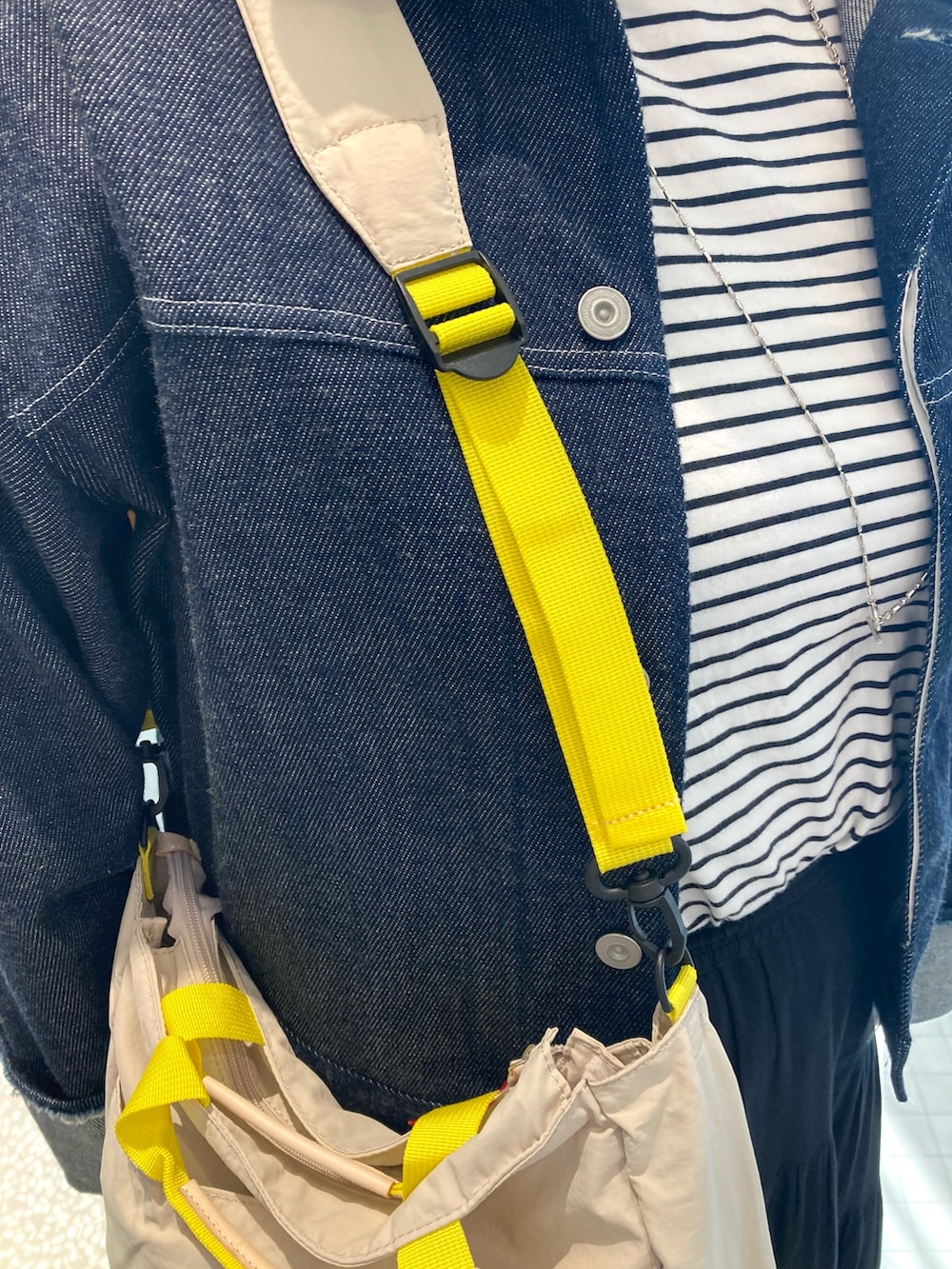 ブルー系のデニムジャケット、ベージュ系のトートバッグ、ブラック系のサンダルを着用したレディースの春コーディネートの8枚目の写真