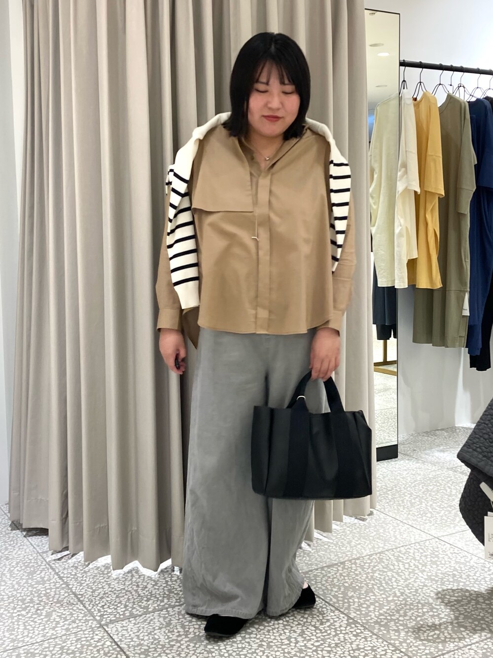 ホワイト系のカーディガン/ボレロ、ベージュ系のシャツ/ブラウス、ブラック系のトートバッグを着用したレディースの秋コーディネートの5枚目の写真