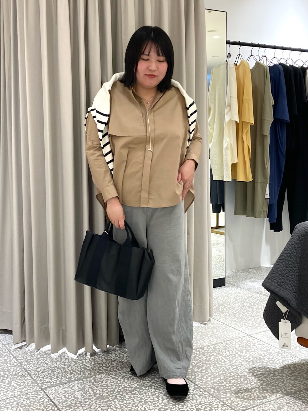 ホワイト系のカーディガン/ボレロ、ベージュ系のシャツ/ブラウス、ブラック系のトートバッグを着用したレディースの秋コーディネートの2枚目の写真