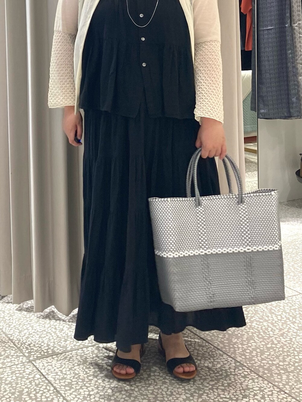 ブラック系のシャツ/ブラウス、シルバー系のかごバッグ、ブラック系のサンダルを着用したレディースの夏コーディネートの5枚目の写真