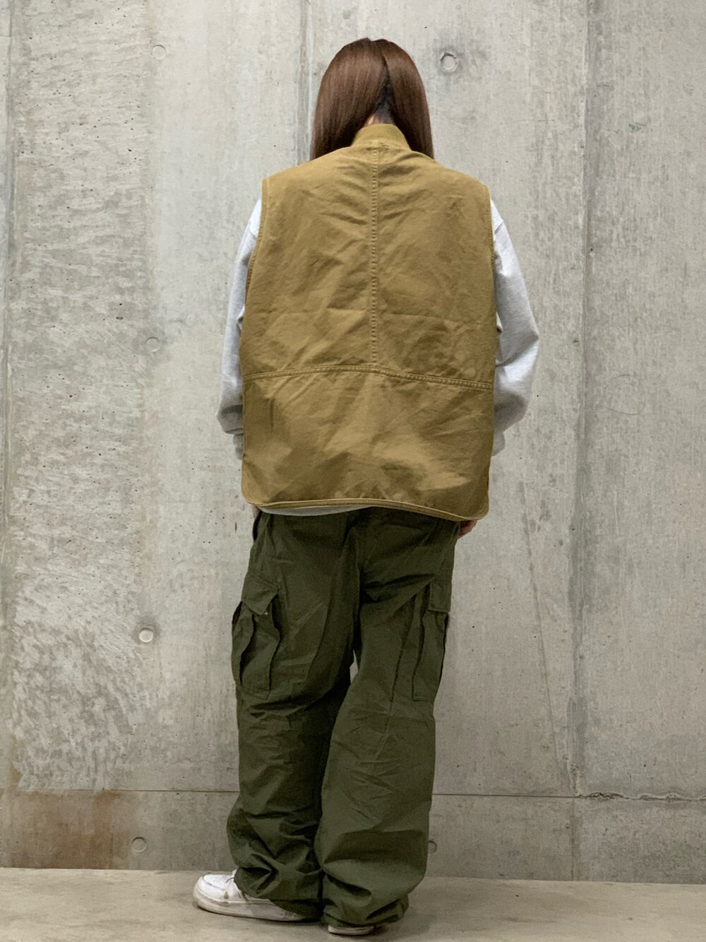 ベージュ系のベスト、グレー系のスウェット、グリーン系のカーゴパンツを着用したレディースの冬コーディネートの2枚目の写真