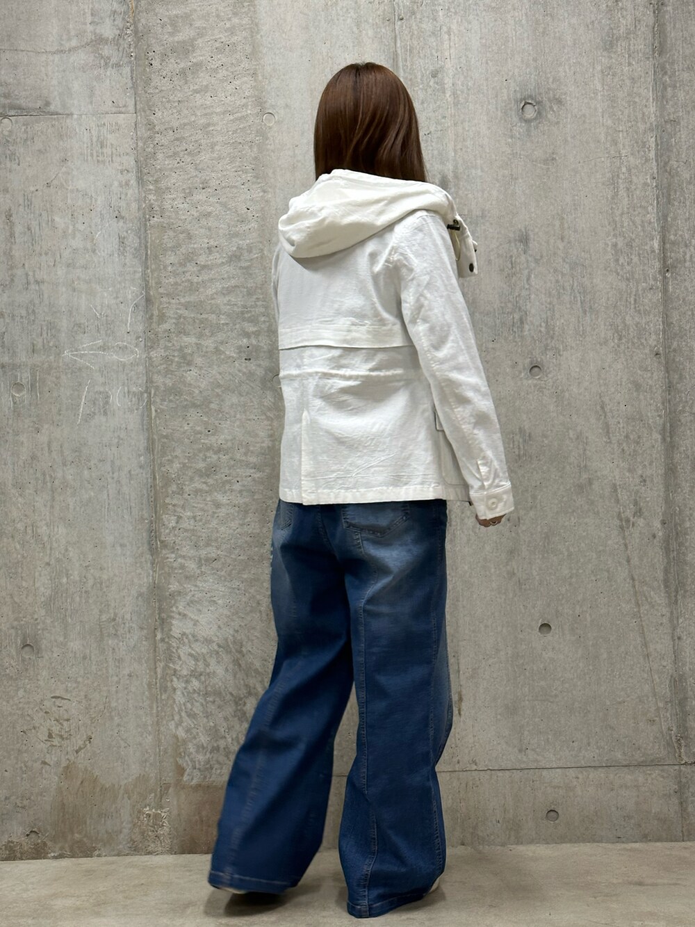 ブルー系のデニムパンツ、ホワイト系のその他アウター、グリーン系のTシャツ/カットソーを着用したレディースの冬コーディネートの3枚目の写真