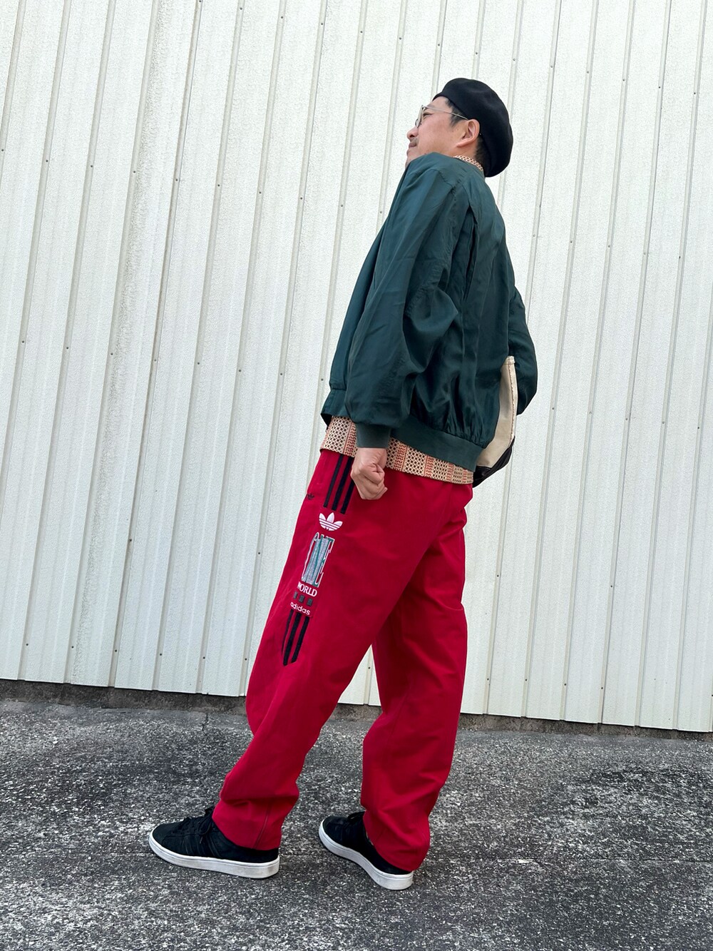 グリーン系のブルゾン、その他のポロシャツ、レッド系のその他パンツを着用したメンズの春コーディネートの4枚目の写真