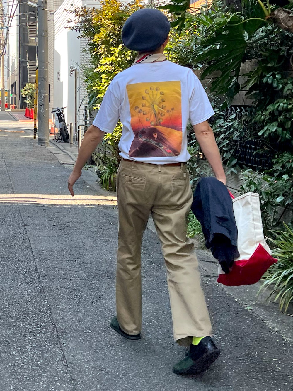 ホワイト系のTシャツ/カットソー、ブルー系のデニムジャケット、ベージュ系のトートバッグを着用したメンズの春コーディネートの2枚目の写真