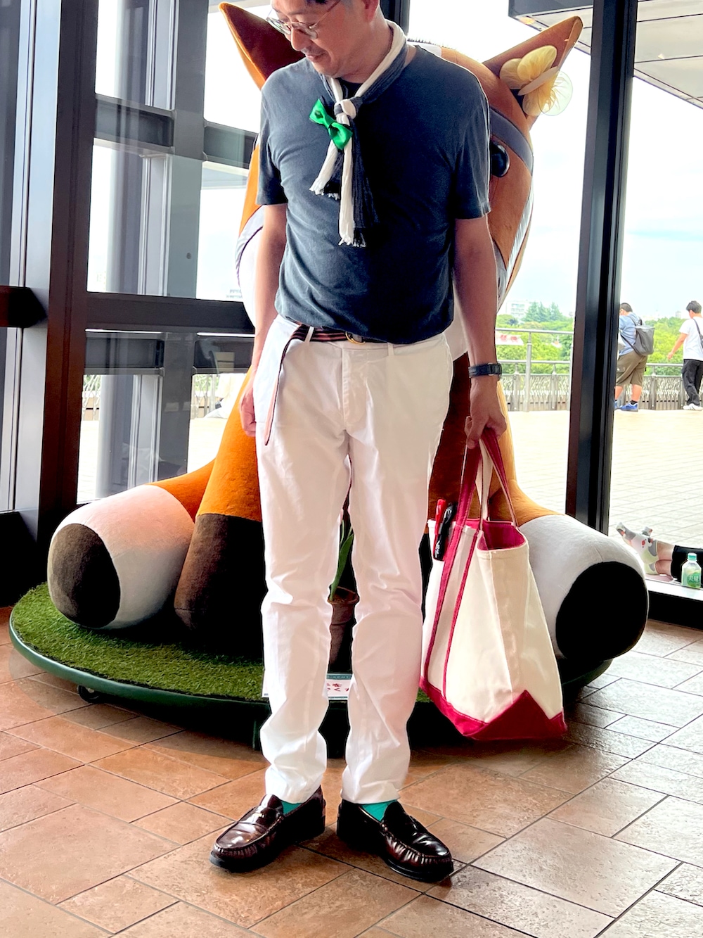 グレー系のTシャツ/カットソー、ホワイト系のチノパンツ、グリーン系のトートバッグを着用したメンズの夏コーディネートの2枚目の写真