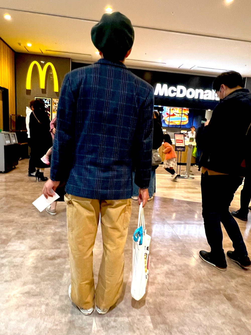 ホワイト系のスニーカー、イエロー系のその他パンツ、ブルー系のテーラードジャケットを着用したメンズの冬コーディネートの2枚目の写真