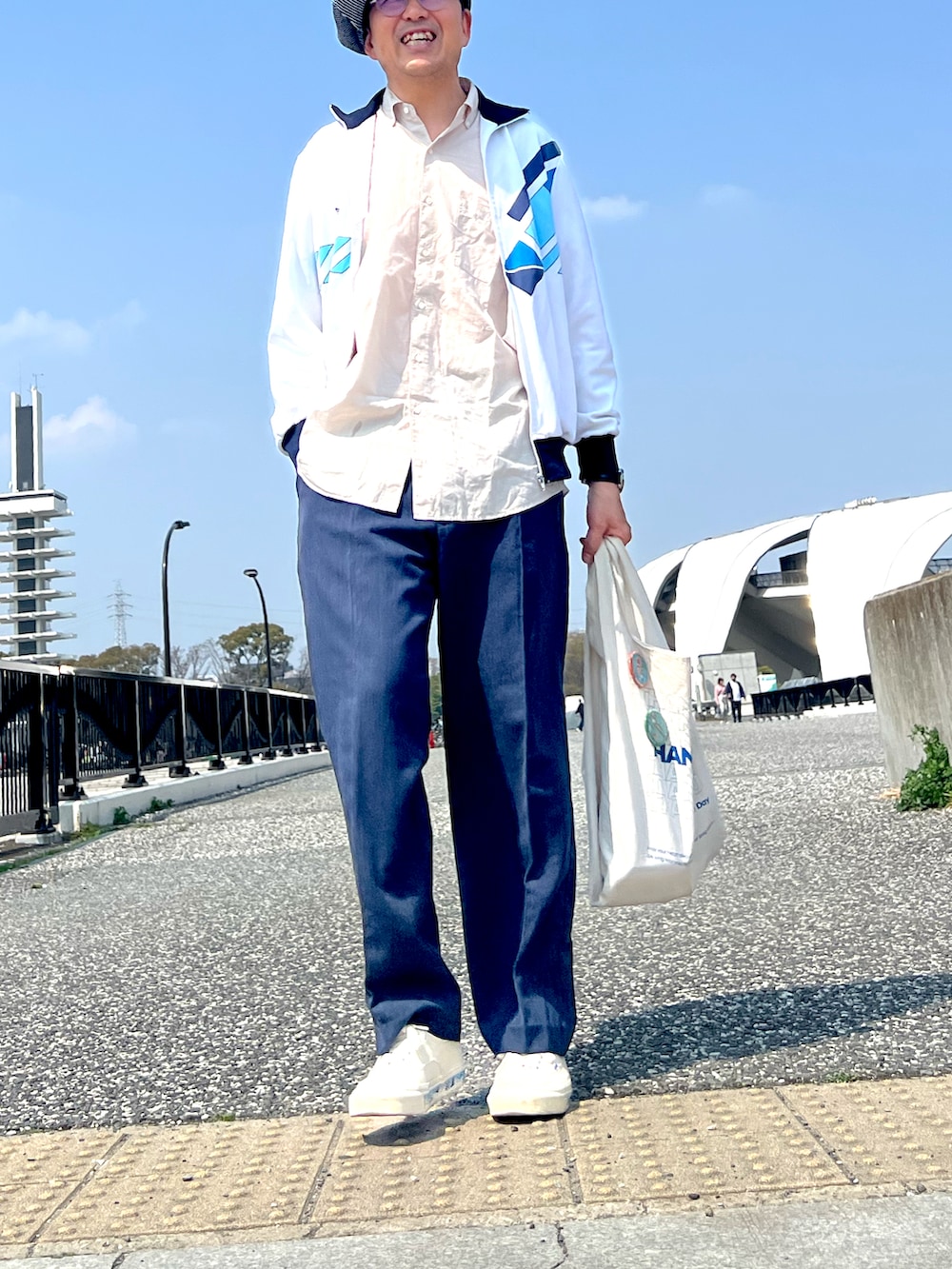 ホワイト系のジャージ、ブルー系のスラックス、ホワイト系のスニーカーを着用したメンズの春コーディネートの4枚目の写真