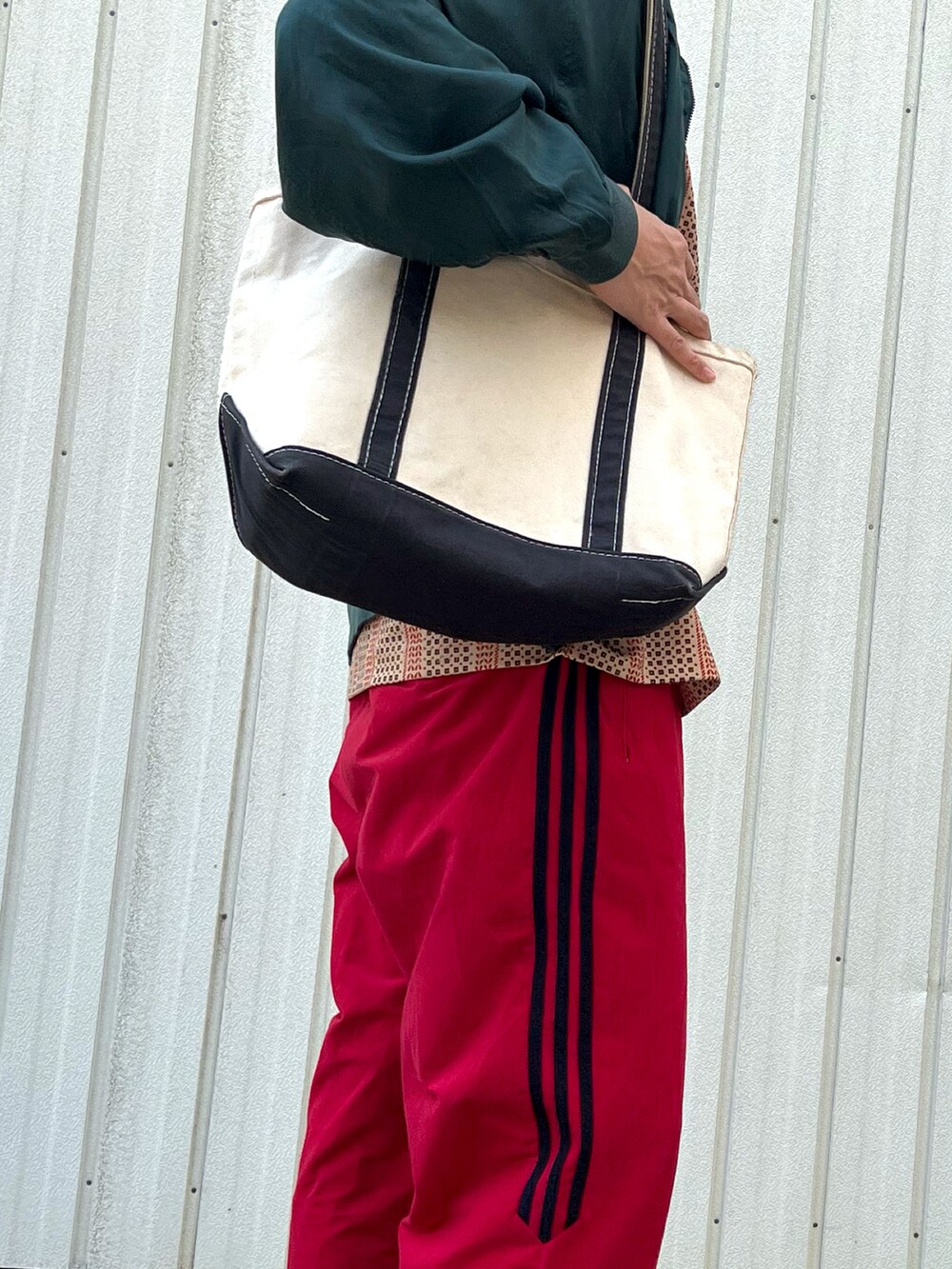 グリーン系のブルゾン、その他のポロシャツ、レッド系のその他パンツを着用したメンズの春コーディネートの3枚目の写真