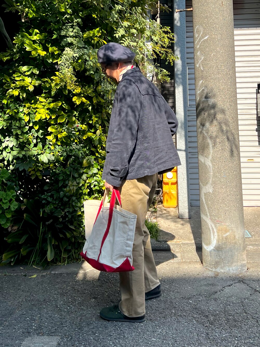ホワイト系のTシャツ/カットソー、ブルー系のデニムジャケット、ベージュ系のトートバッグを着用したメンズの春コーディネートの3枚目の写真