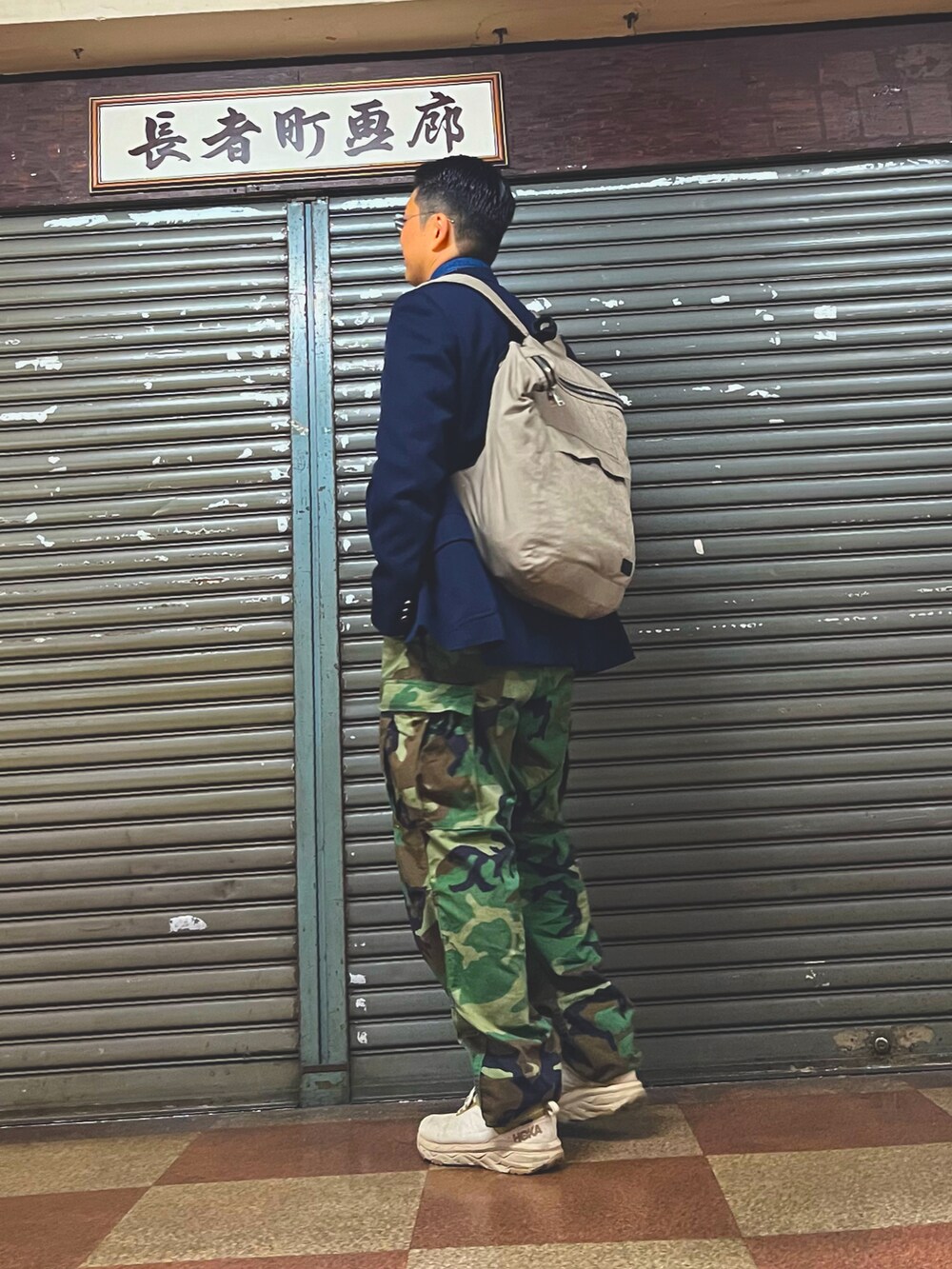 グリーン系のカーゴパンツ、ベージュ系のスニーカー、ブルー系のテーラードジャケットを着用したメンズの春コーディネートの3枚目の写真