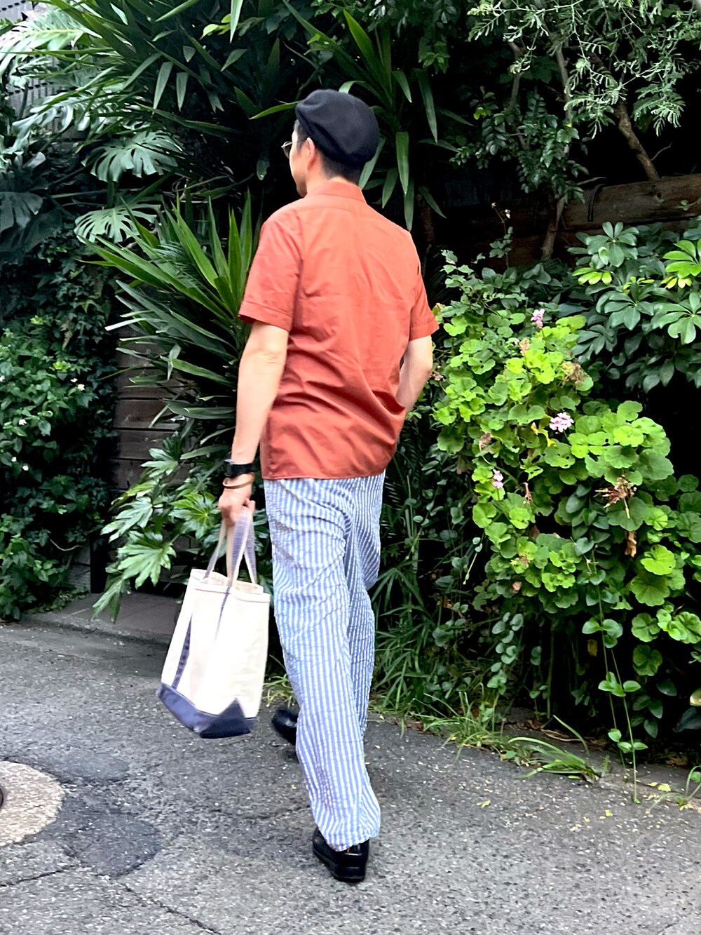 ブラウン系のシャツ/ブラウス、ブルー系のその他パンツ、ベージュ系のトートバッグを着用したメンズの夏コーディネートの2枚目の写真