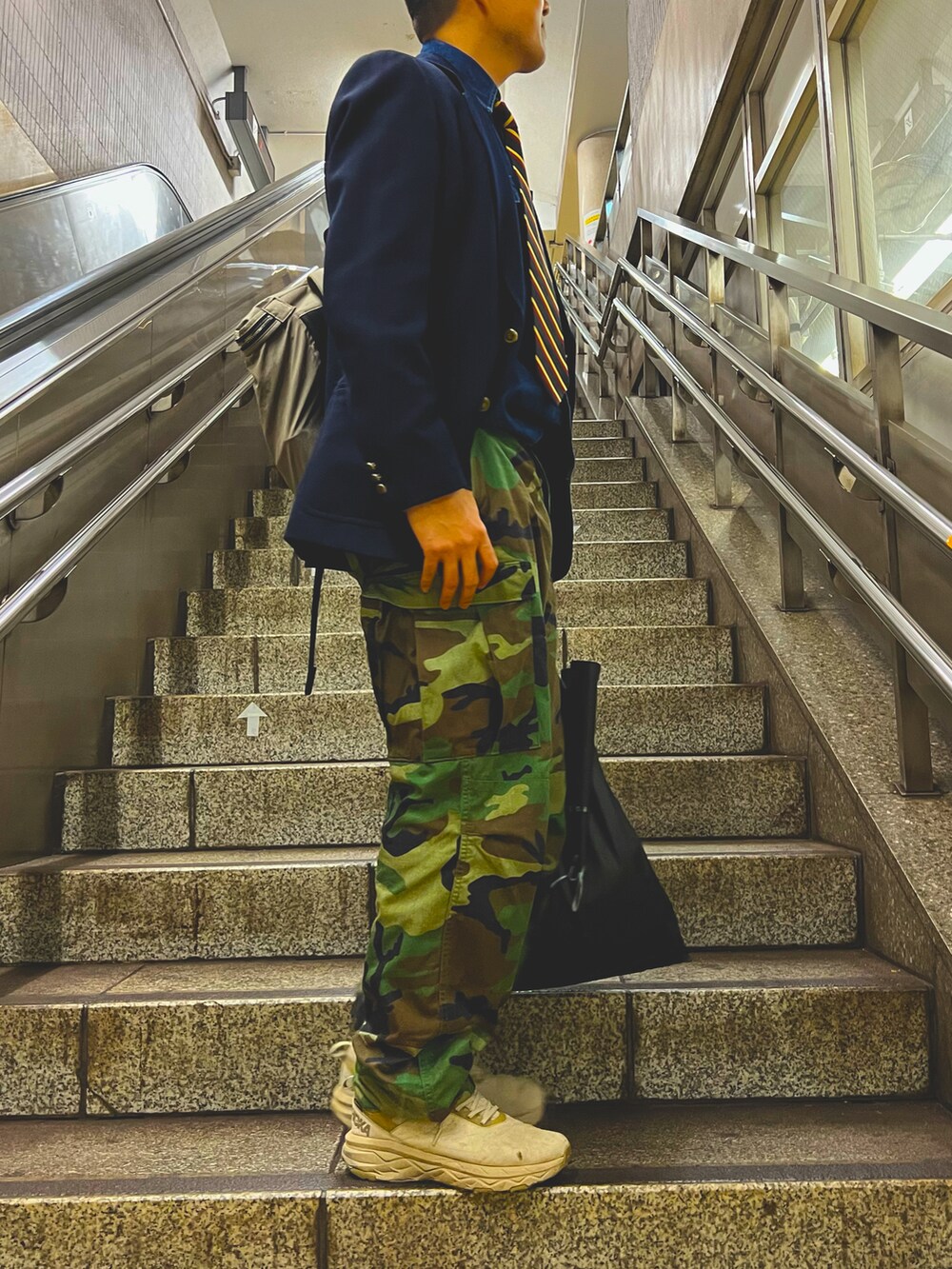 グリーン系のカーゴパンツ、ベージュ系のスニーカー、ブルー系のテーラードジャケットを着用したメンズの春コーディネートの2枚目の写真