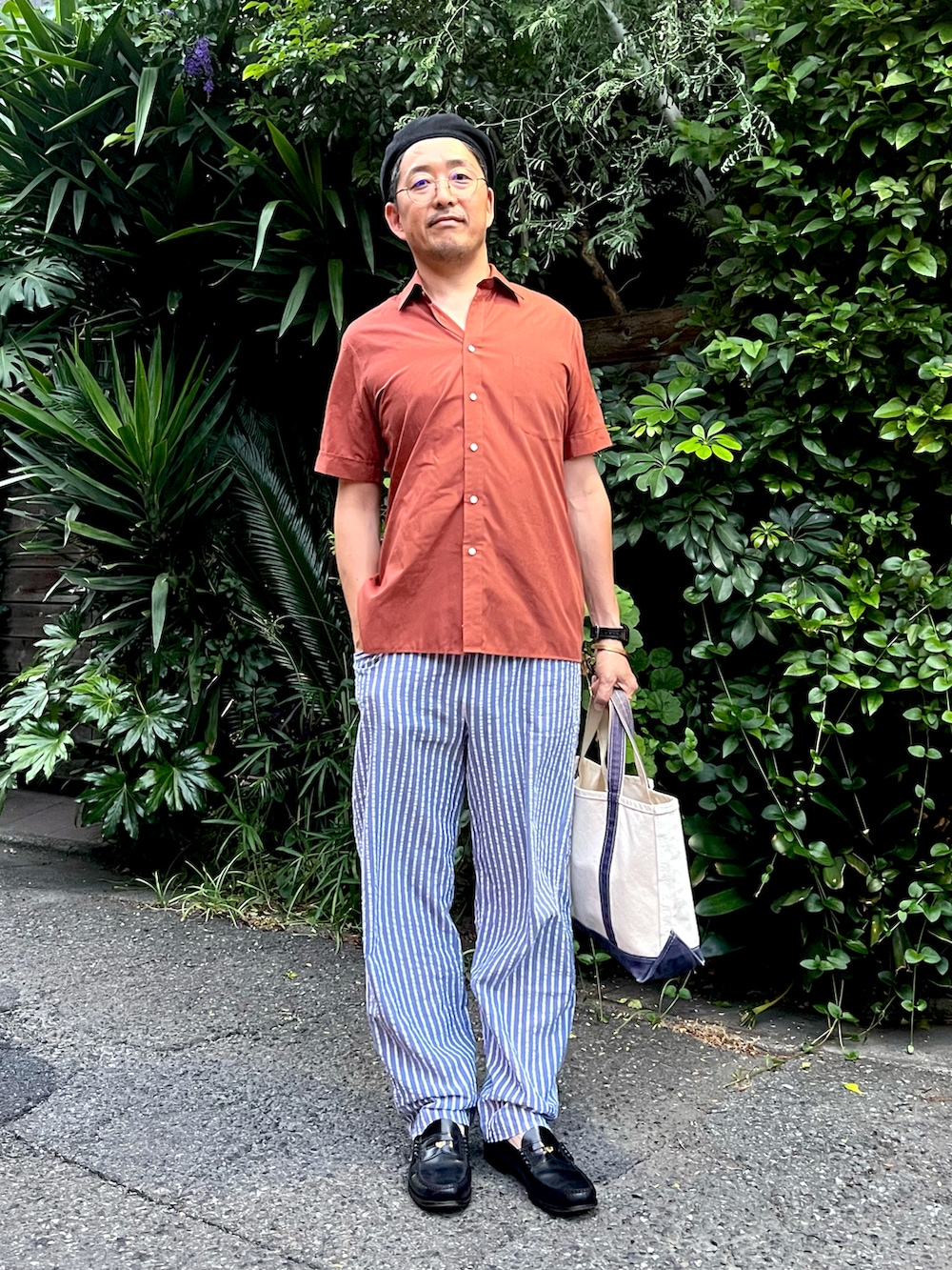 ブラウン系のシャツ/ブラウス、ブルー系のその他パンツ、ベージュ系のトートバッグを着用したメンズの夏コーディネートの3枚目の写真