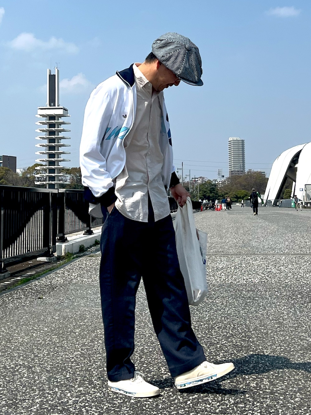 ホワイト系のジャージ、ブルー系のスラックス、ホワイト系のスニーカーを着用したメンズの春コーディネートの3枚目の写真