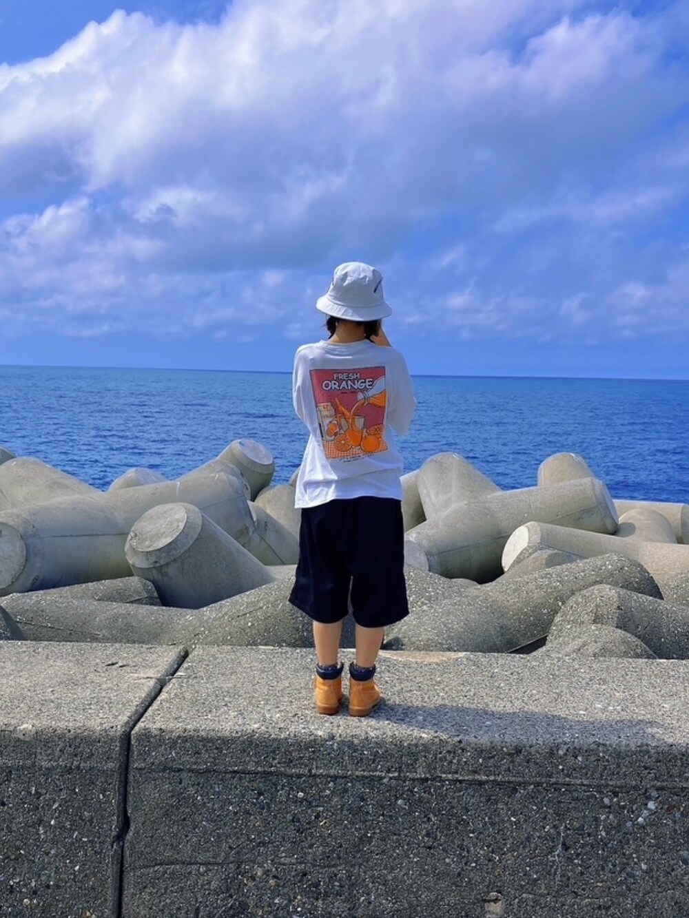 ホワイト系のTシャツ/カットソー、ブラック系のパンツ、ブラウン系のブーツを着用したレディースの夏コーディネートの3枚目の写真