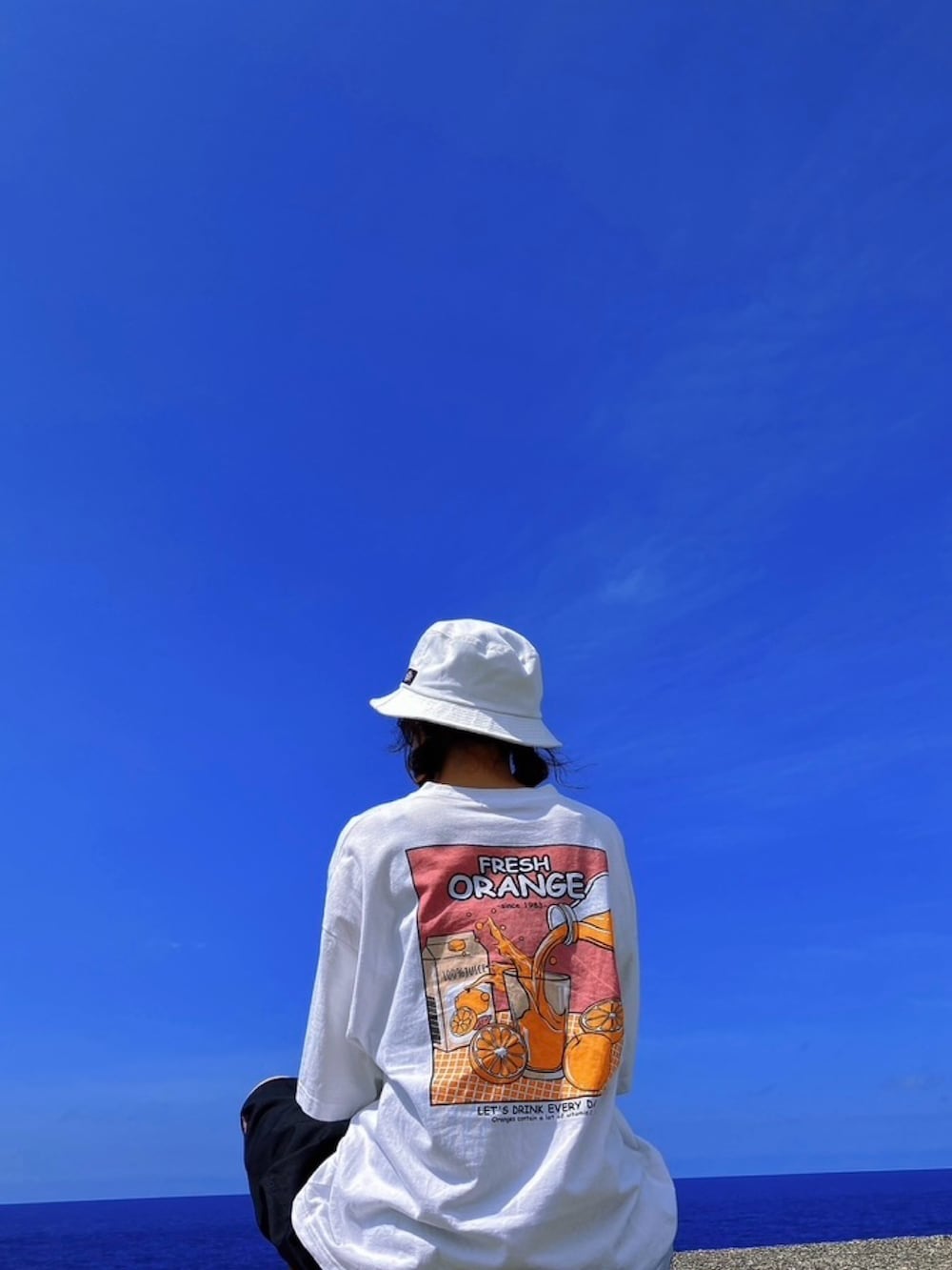 ホワイト系のTシャツ/カットソー、ブラック系のパンツ、ブラウン系のブーツを着用したレディースの夏コーディネートの2枚目の写真