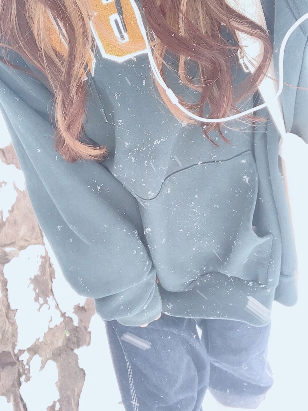 ブルー系のデニムパンツ、グリーン系のパーカー、ホワイト系のブーツを着用したレディースの冬コーディネートの3枚目の写真