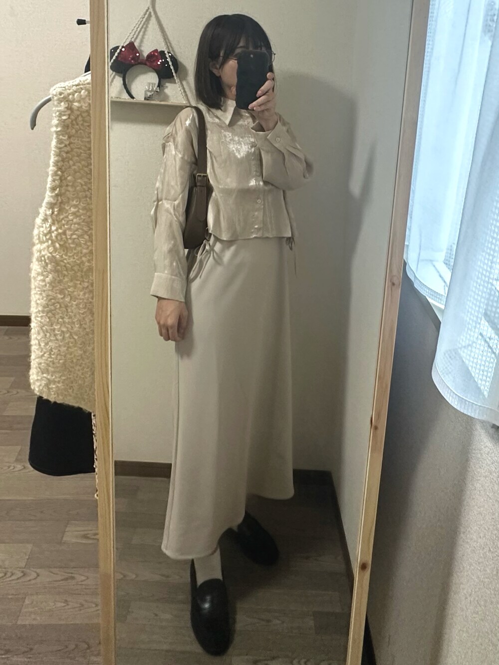 ブラウン系のハンドバッグ、ベージュ系のシャツ/ブラウス、ベージュ系のワンピースを着用したレディースの秋コーディネートの2枚目の写真