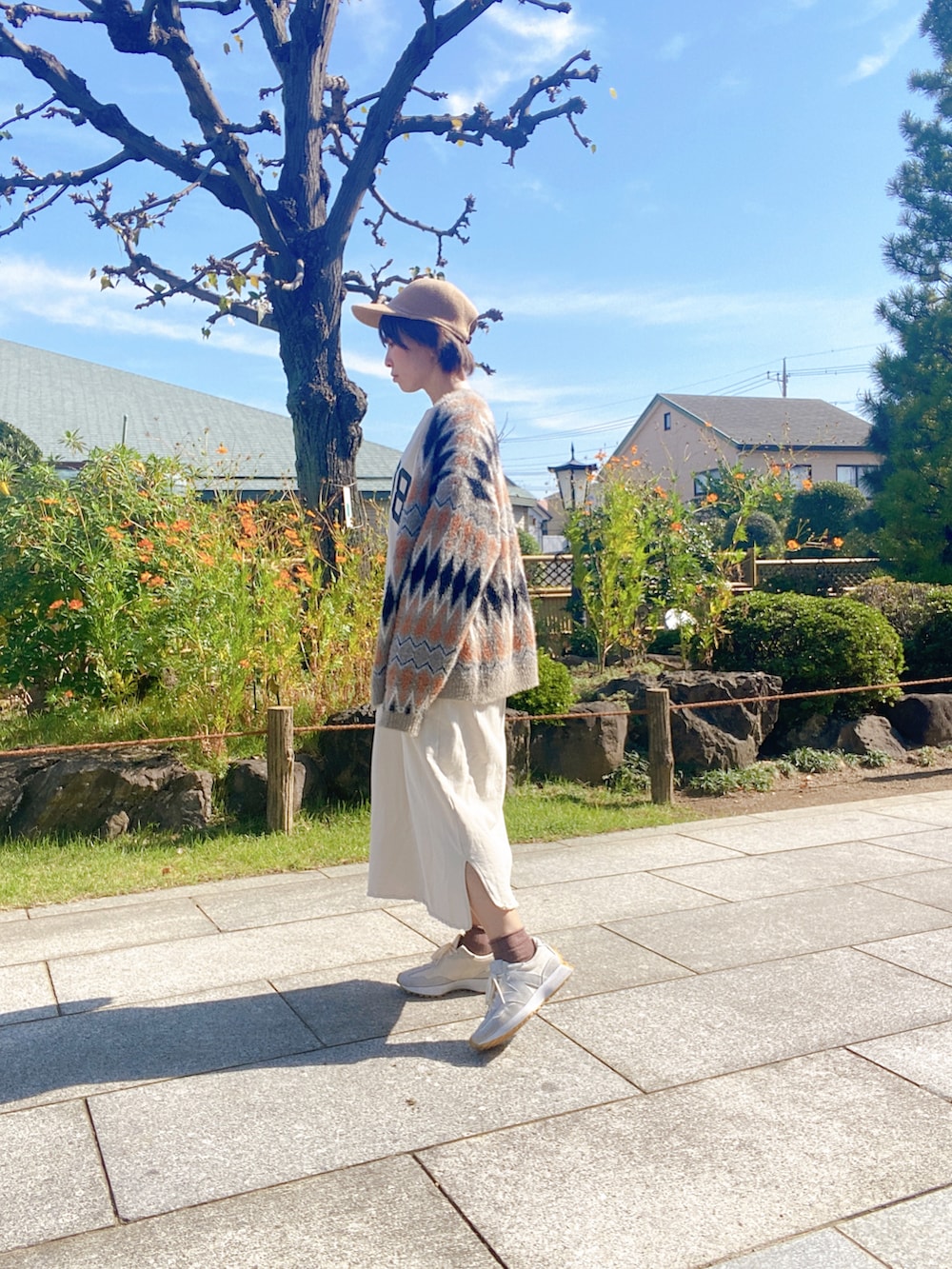 ホワイト系のスニーカー、ホワイト系のワンピース、その他のニット/セーターを着用したレディースの秋コーディネートの2枚目の写真