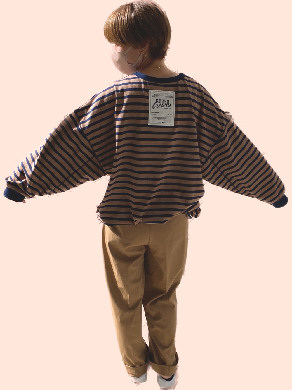 ブラック系のスニーカー、ブラウン系のTシャツ/カットソー、ベージュ系のパンツを着用したレディースの秋コーディネートの2枚目の写真