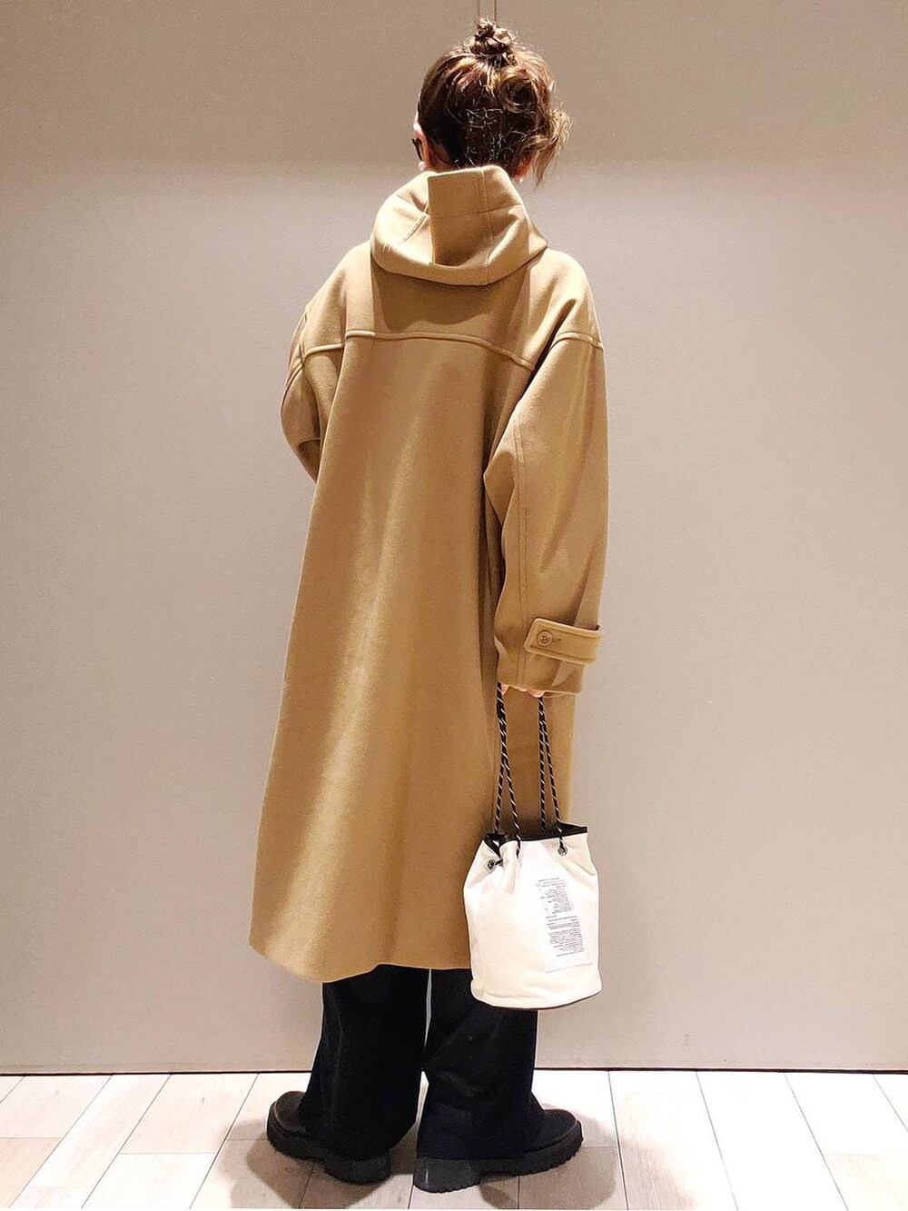 ホワイト系のニット/セーター、ブラック系のブーツ、ブラック系のその他パンツを着用したレディースの冬コーディネートの3枚目の写真