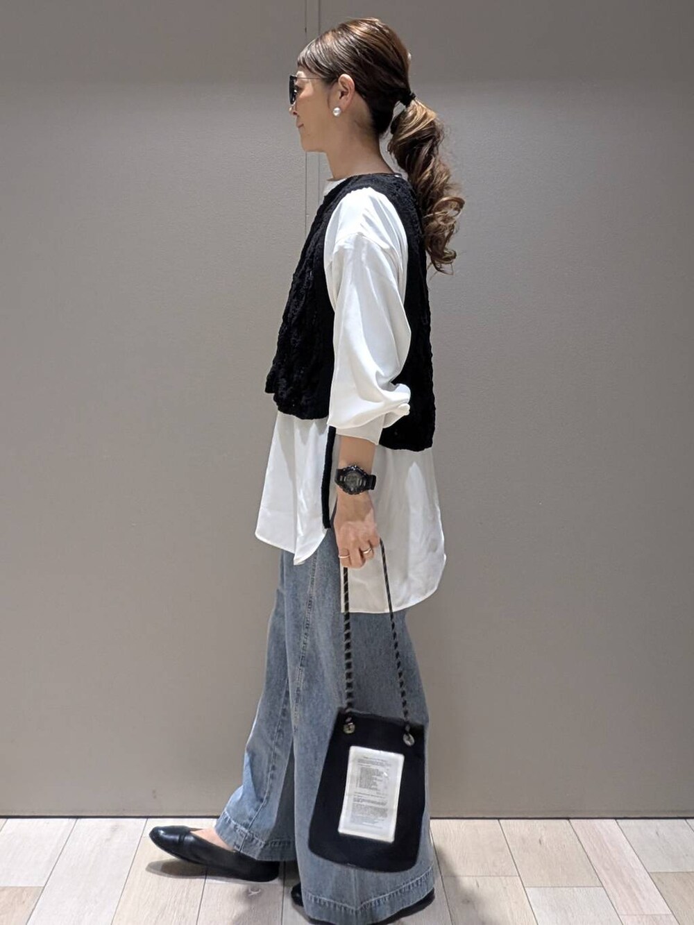 ホワイト系のシャツ/ブラウス、ブラック系のベスト、ブルー系のデニムパンツを着用したレディースの春コーディネートの2枚目の写真