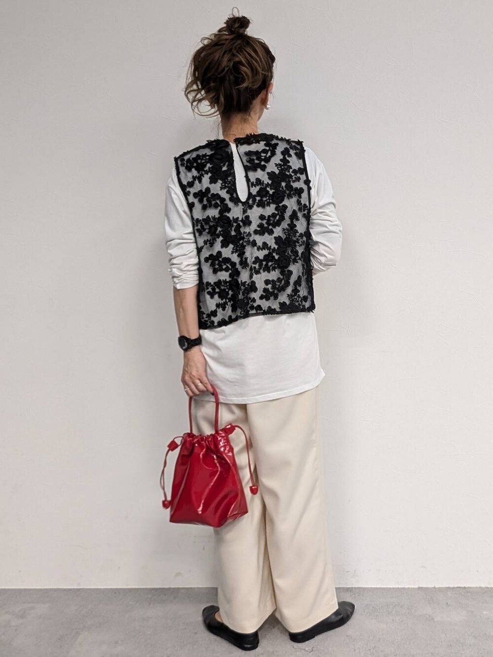 ホワイト系のTシャツ/カットソー、ホワイト系のスラックス、ブラック系のベストを着用したレディースの冬コーディネートの3枚目の写真