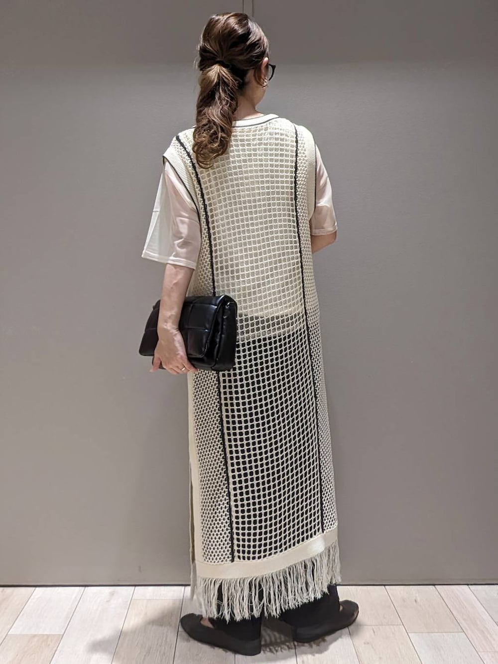 ブラック系のショルダーバッグ、ホワイト系のTシャツ/カットソー、ブラック系のパンプスを着用したレディースの春コーディネートの3枚目の写真