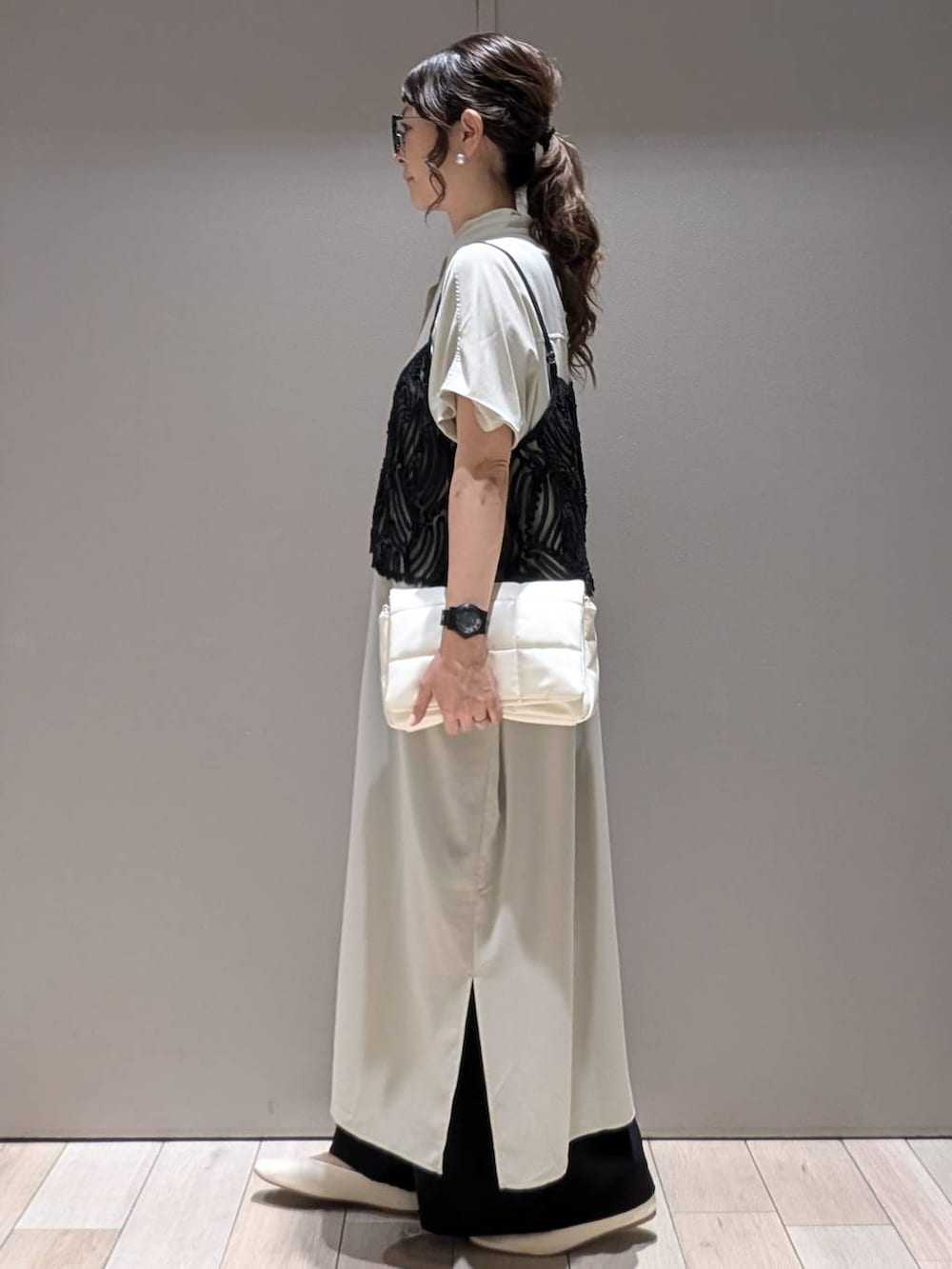 ホワイト系のショルダーバッグ、ブラック系のその他パンツ、ホワイト系のパンプスを着用したレディースの夏コーディネートの2枚目の写真