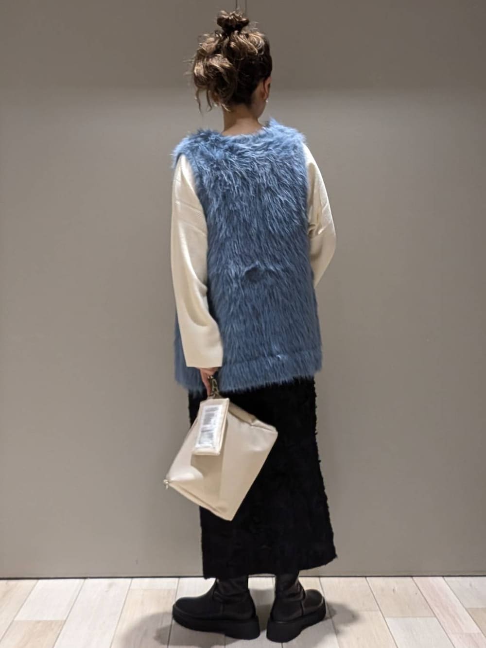 ブラック系のブーツ、ホワイト系のニット/セーター、ブラック系のドレスを着用したレディースの秋コーディネートの3枚目の写真