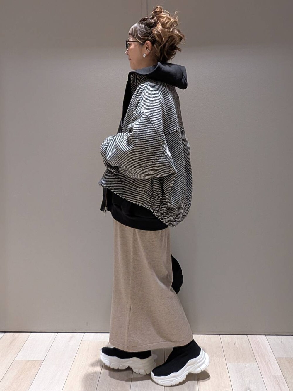 ブラック系のショルダーバッグ、ブラック系のブルゾン、ブラック系のパーカーを着用したレディースの冬コーディネートの2枚目の写真