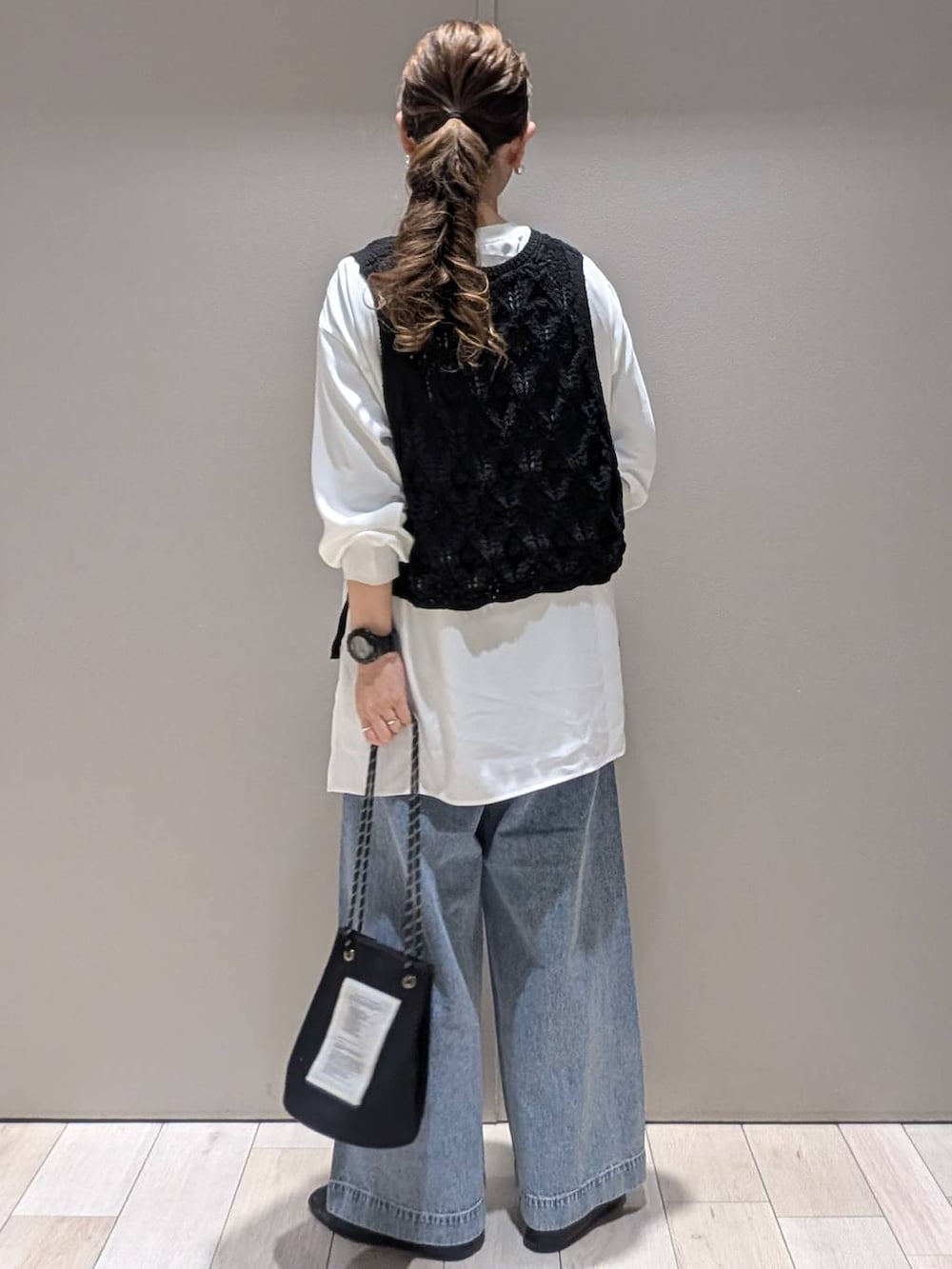 ホワイト系のシャツ/ブラウス、ブラック系のベスト、ブルー系のデニムパンツを着用したレディースの春コーディネートの3枚目の写真