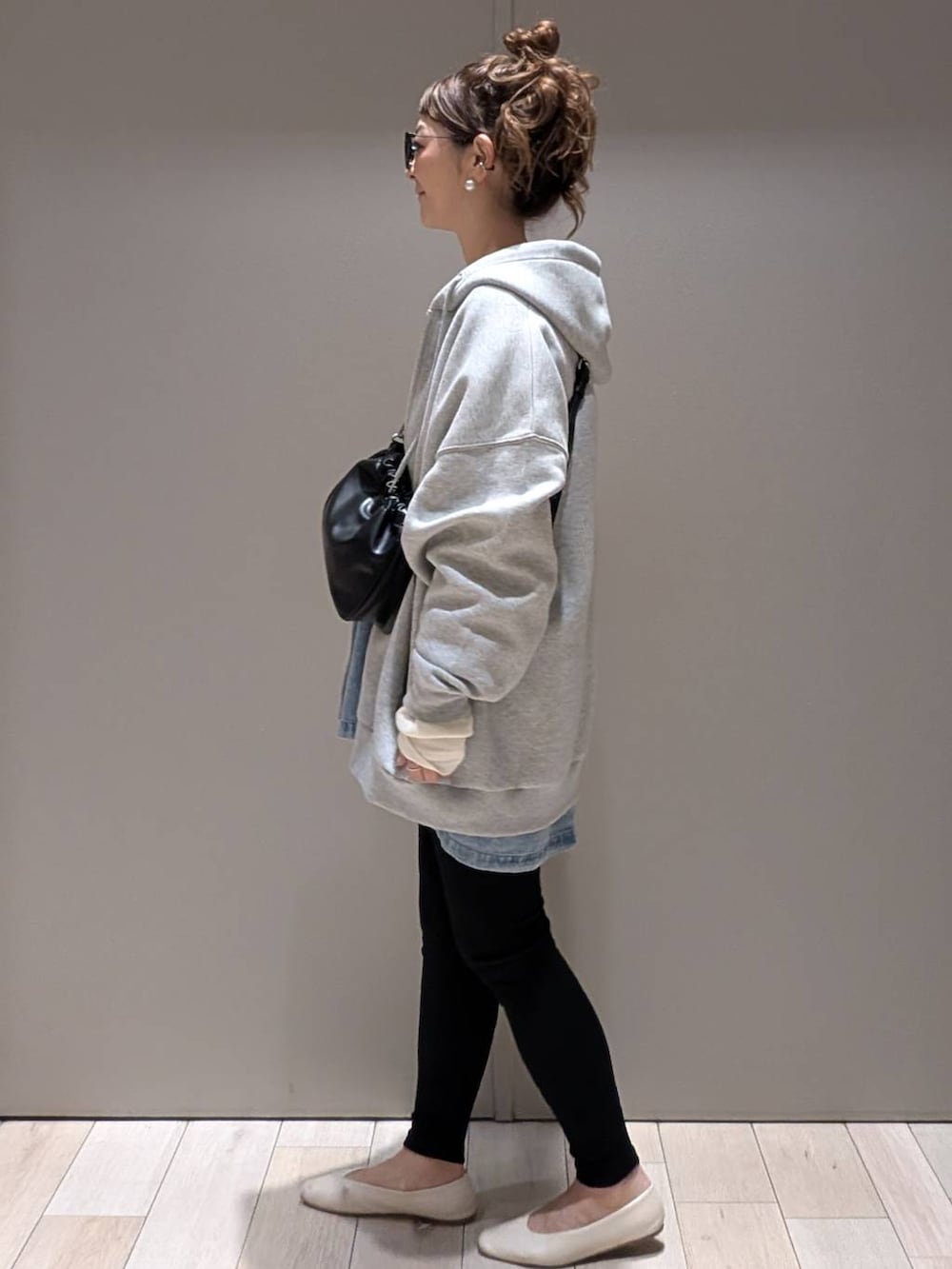 ブラック系のショルダーバッグ、ブルー系のシャツ/ブラウス、ホワイト系のTシャツ/カットソーを着用したレディースの秋コーディネートの2枚目の写真