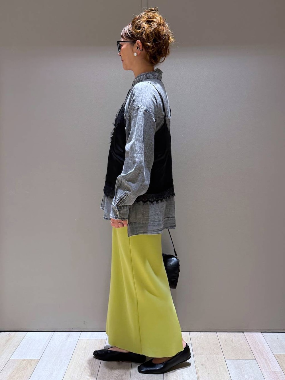 グリーン系のスカート、ブラック系のパンプス、グレー系のシャツ/ブラウスを着用したレディースの春コーディネートの2枚目の写真