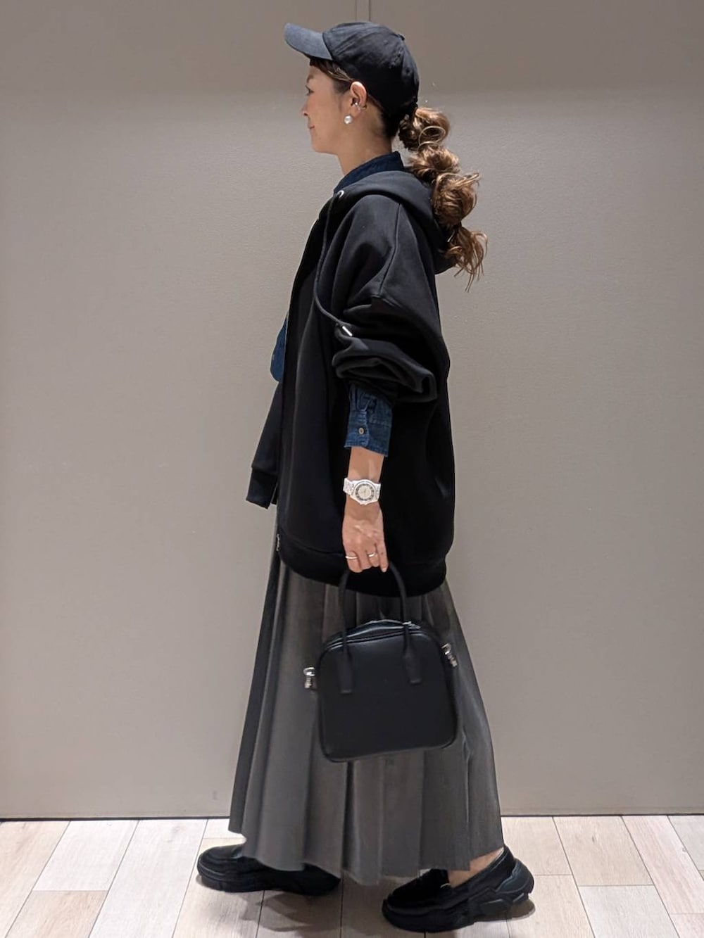 グレー系のスカート、ブラック系のスニーカー、ブルー系のシャツ/ブラウスを着用したレディースの秋コーディネートの2枚目の写真