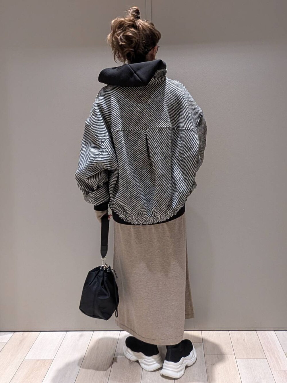 ブラック系のショルダーバッグ、ブラック系のブルゾン、ブラック系のパーカーを着用したレディースの冬コーディネートの3枚目の写真