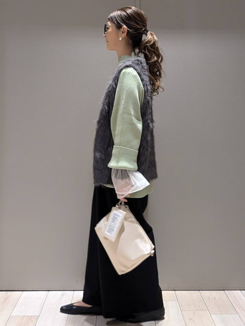 ブラック系のその他パンツ、グリーン系のニット/セーター、ブラック系のパンプスを着用したレディースの秋コーディネートの2枚目の写真