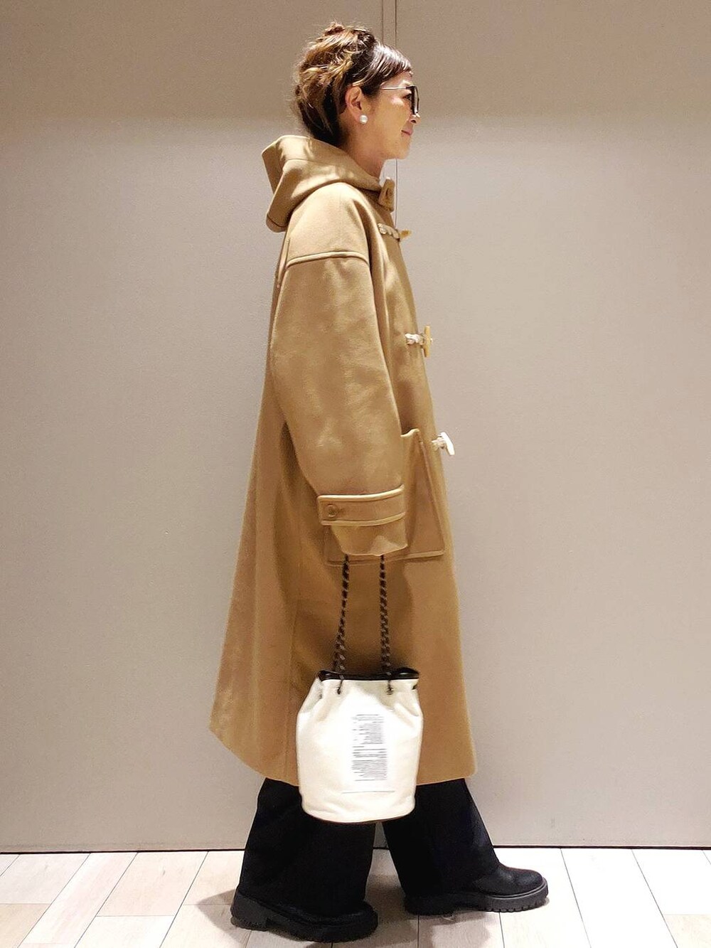 ホワイト系のニット/セーター、ブラック系のブーツ、ブラック系のその他パンツを着用したレディースの冬コーディネートの2枚目の写真