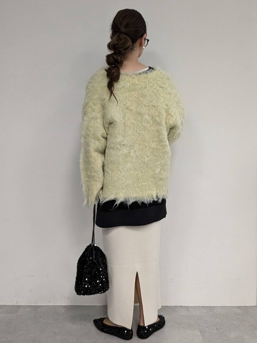 ブラック系のパンプス、ブラック系のショルダーバッグ、ホワイト系のスカートを着用したレディースの秋コーディネートの3枚目の写真